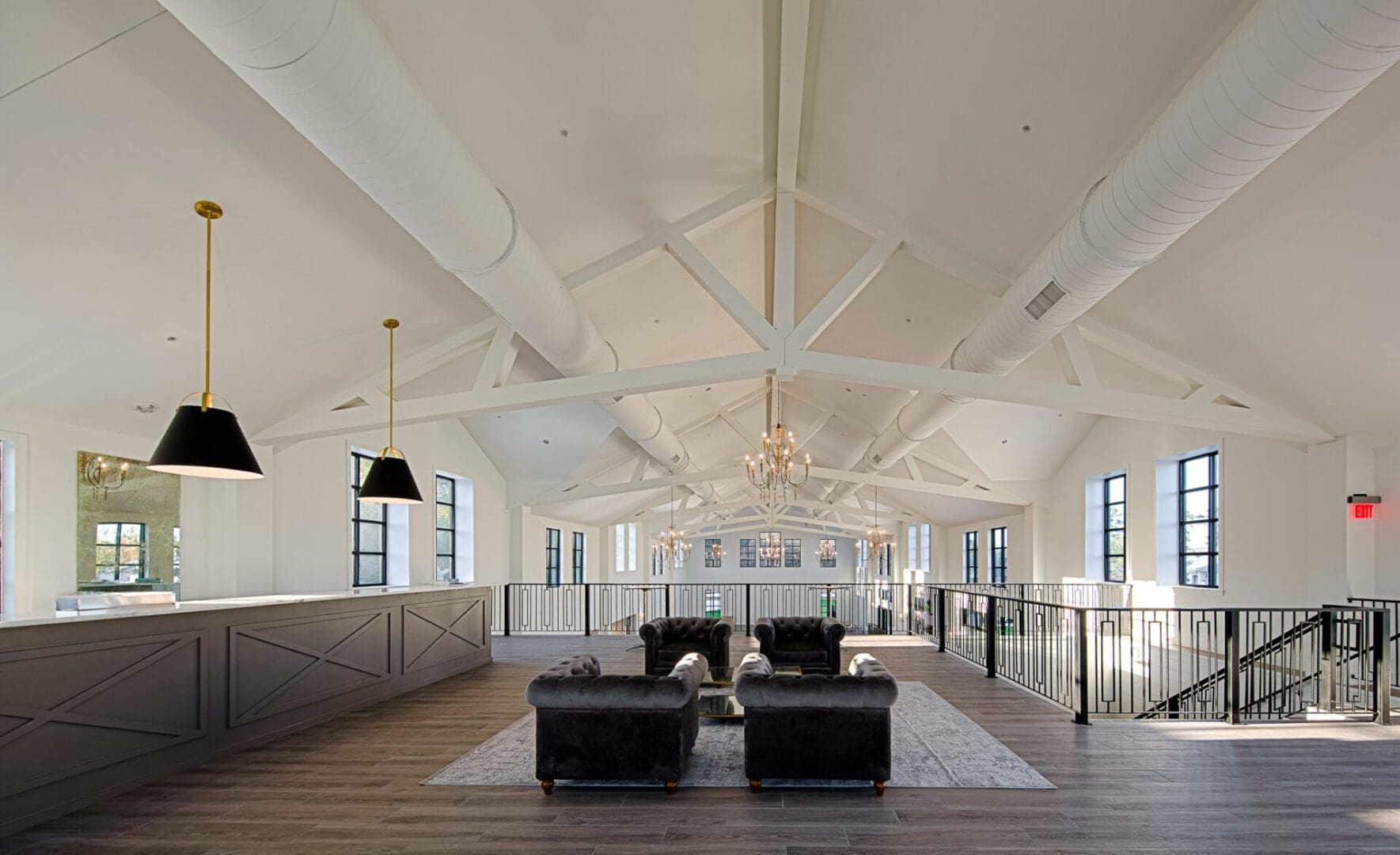 Spacious loft with modern furnishings and chandeliers.