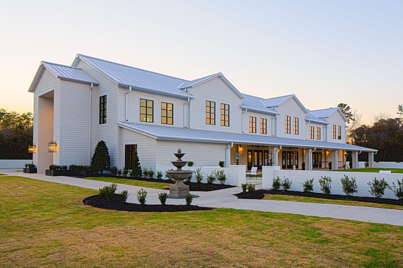 Large white house with manicured lawn.