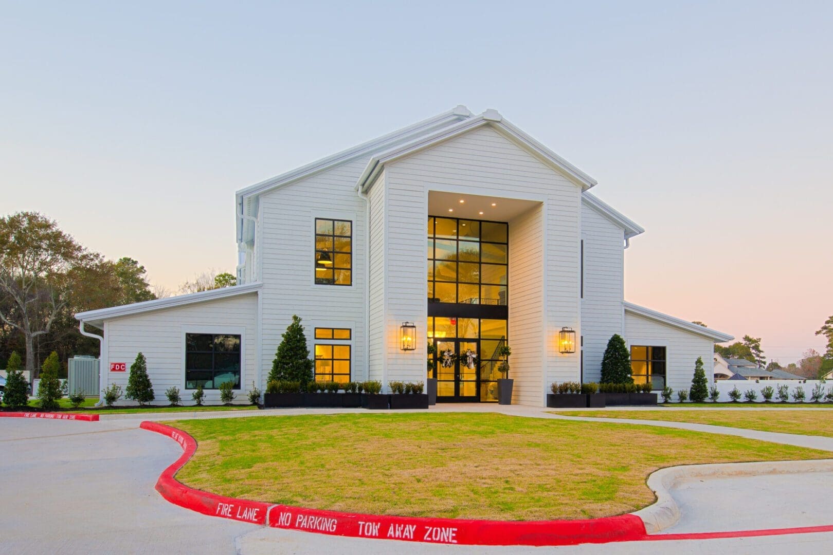 Modern white building with large glass windows.