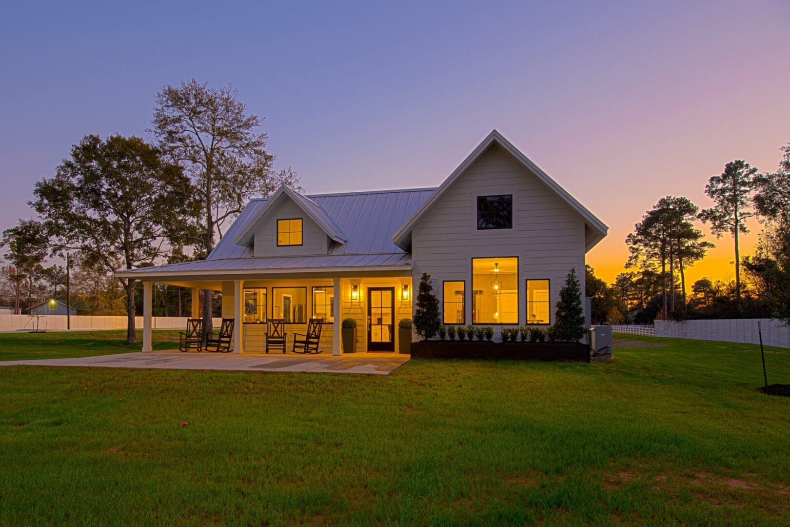 House at sunset with porch and lights.