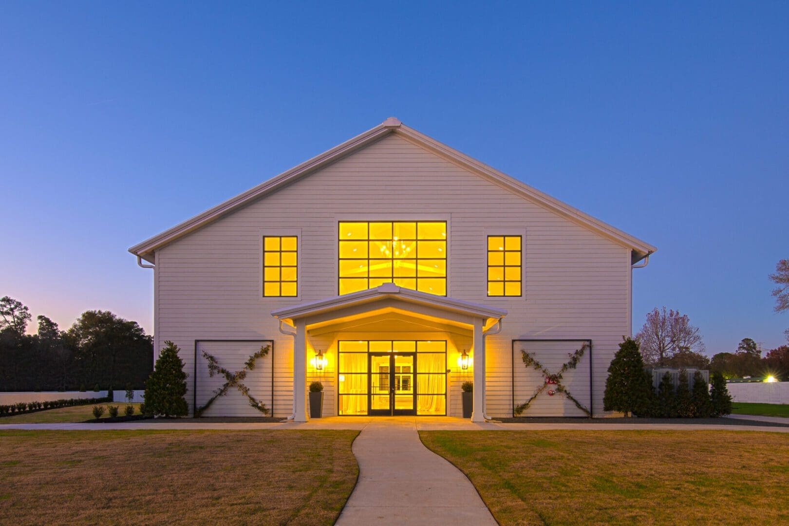 Illuminated building at dusk with pathway.