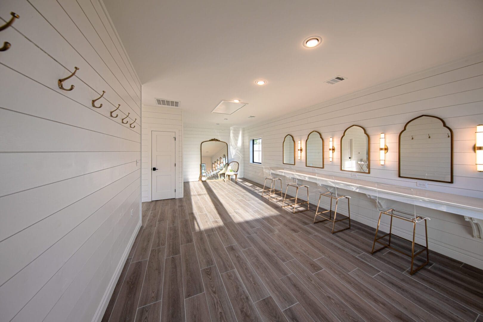 Spacious dressing room with mirrors and hooks.