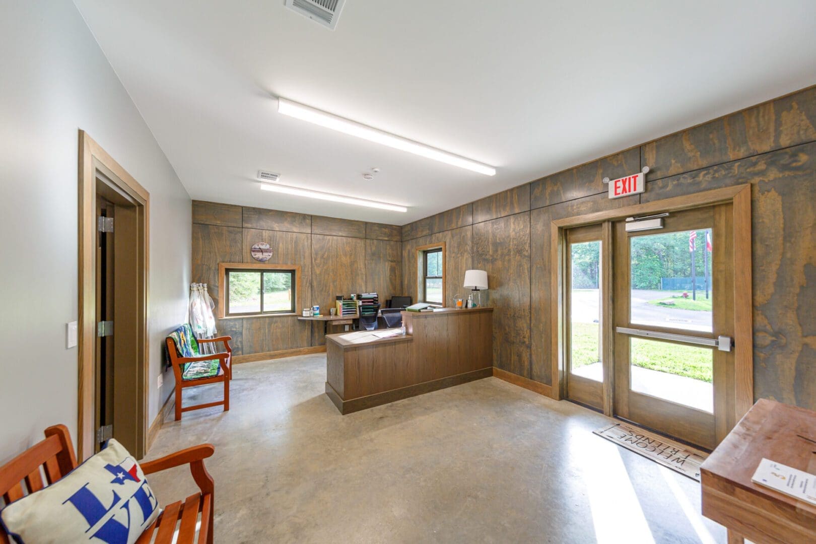 Office lobby with wooden desk and seating.