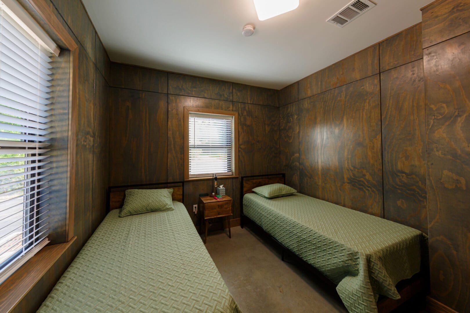 Two beds in a small wooden room.