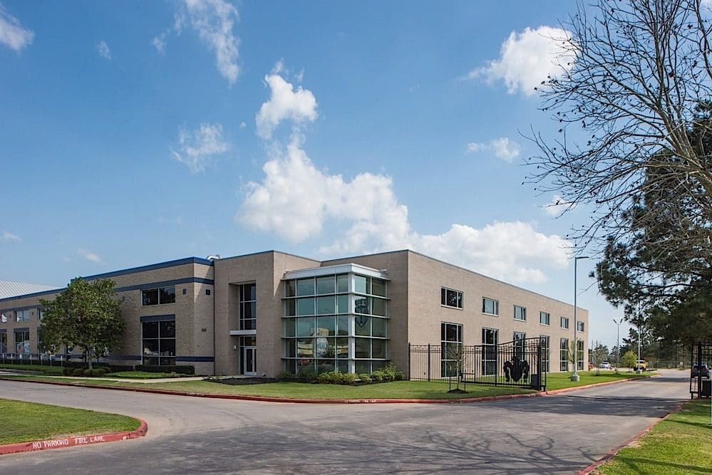 Modern building with glass entrance under blue sky.