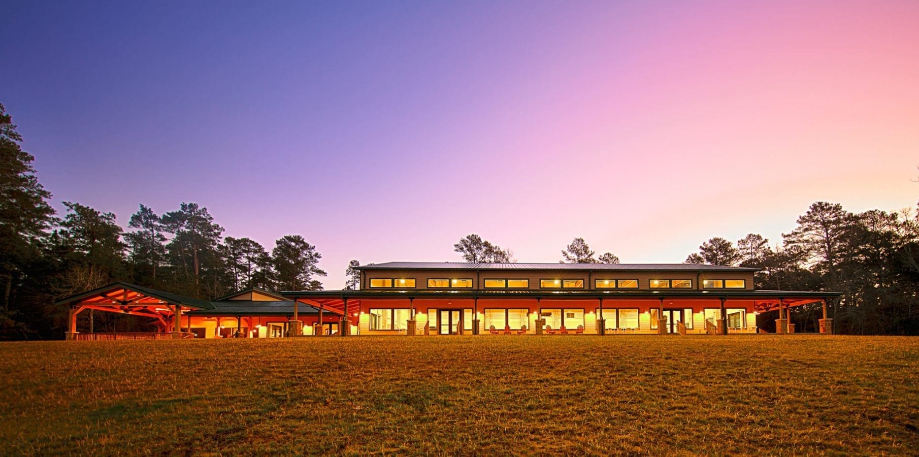 Modern building with illuminated windows at sunset.