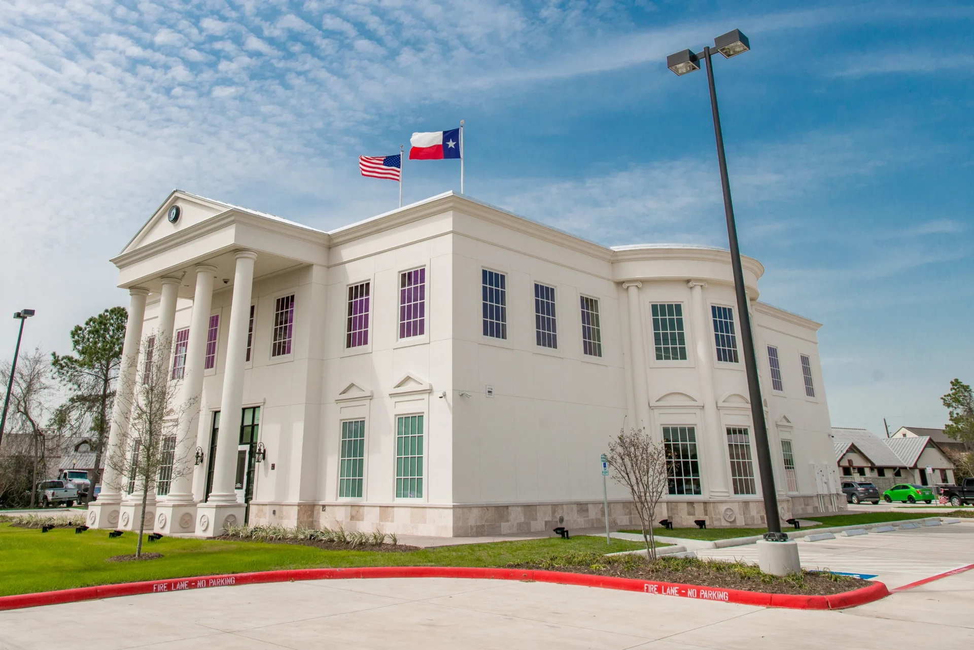 White building with flags and columns.