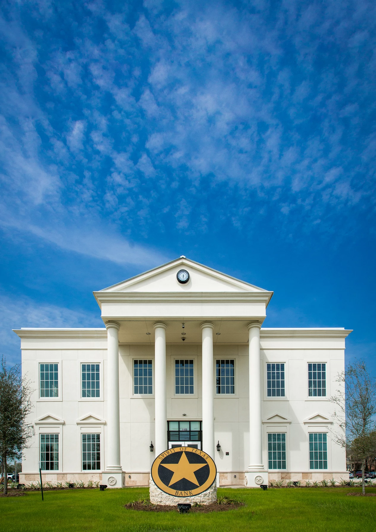 White building with columns and blue sky.