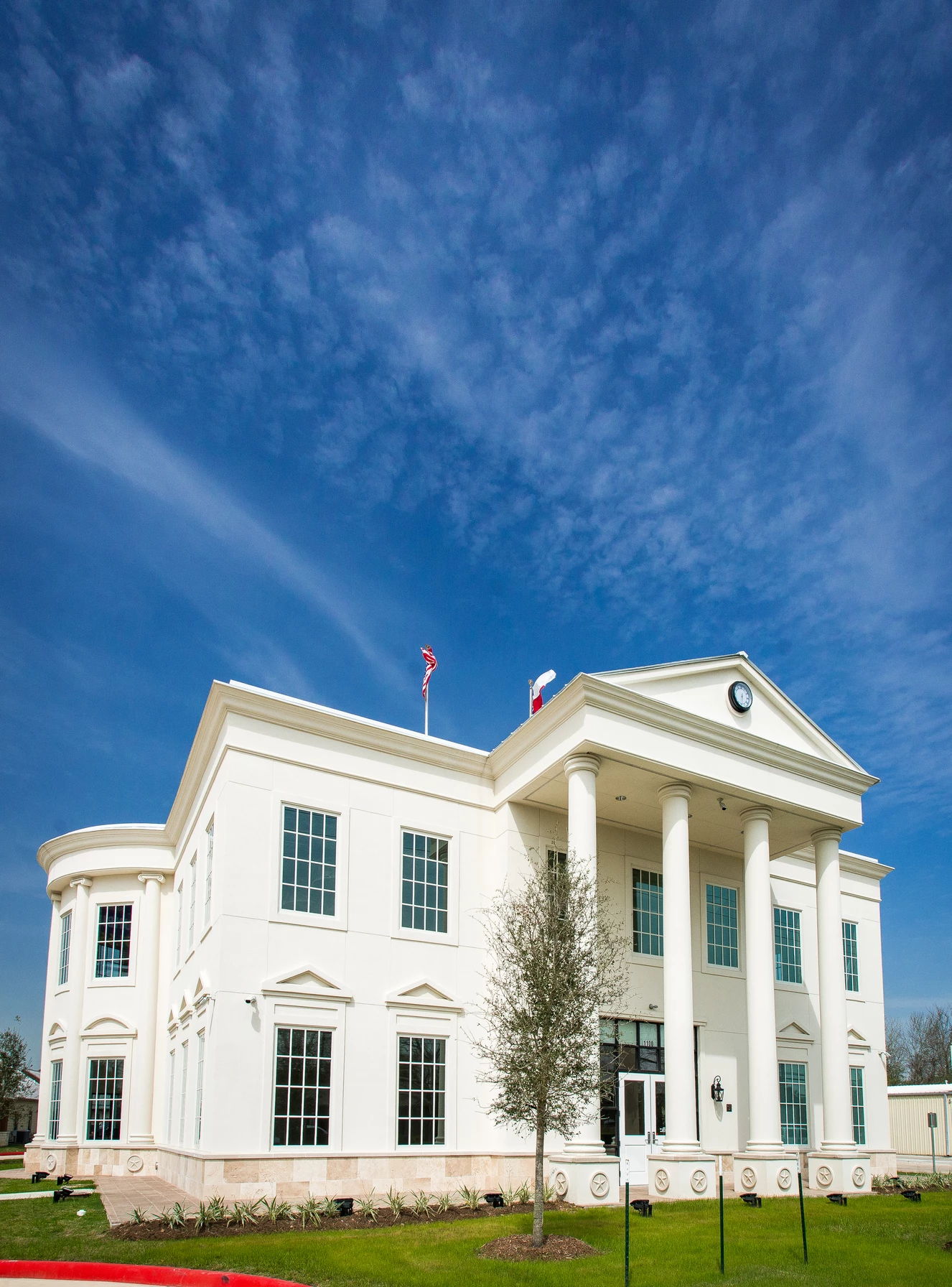 White building with columns under blue sky.