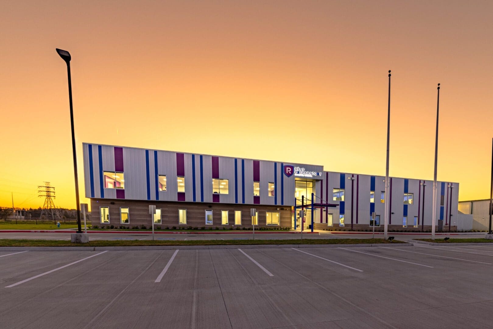 Modern building at sunset with parking lot.