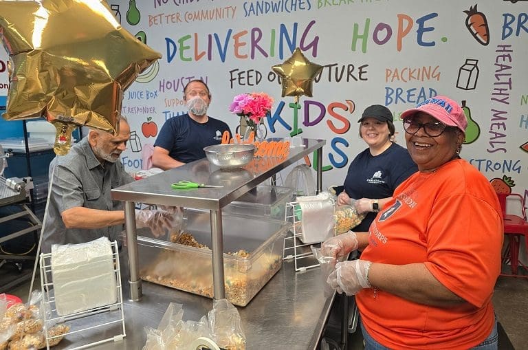People preparing food in a colorful kitchen.