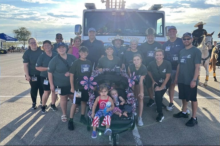 Group posing in front of a truck.