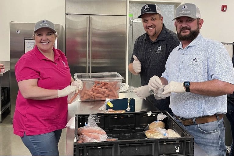 People packing food in a kitchen.