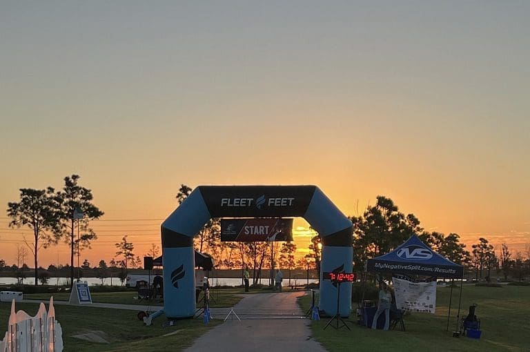 Race start line at sunrise with tents.