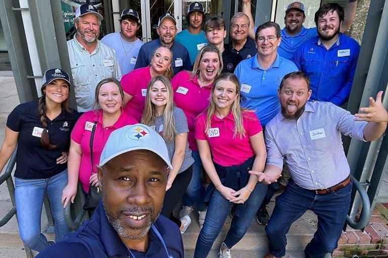 Group of people posing and smiling outdoors.