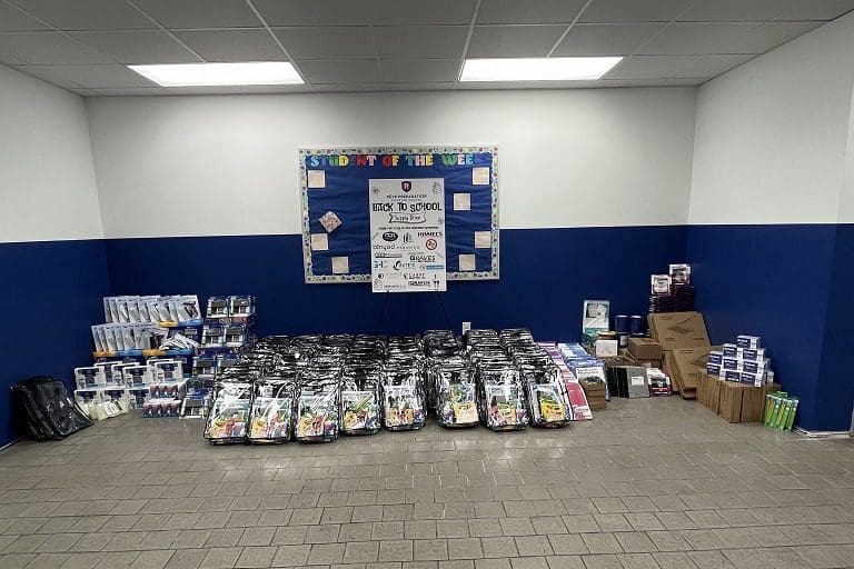 Backpacks and supplies arranged for school donation.