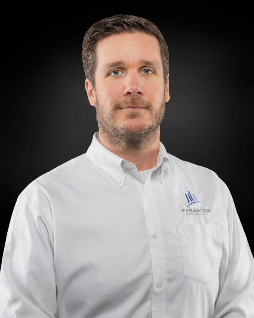 Man in white shirt, dark background.
